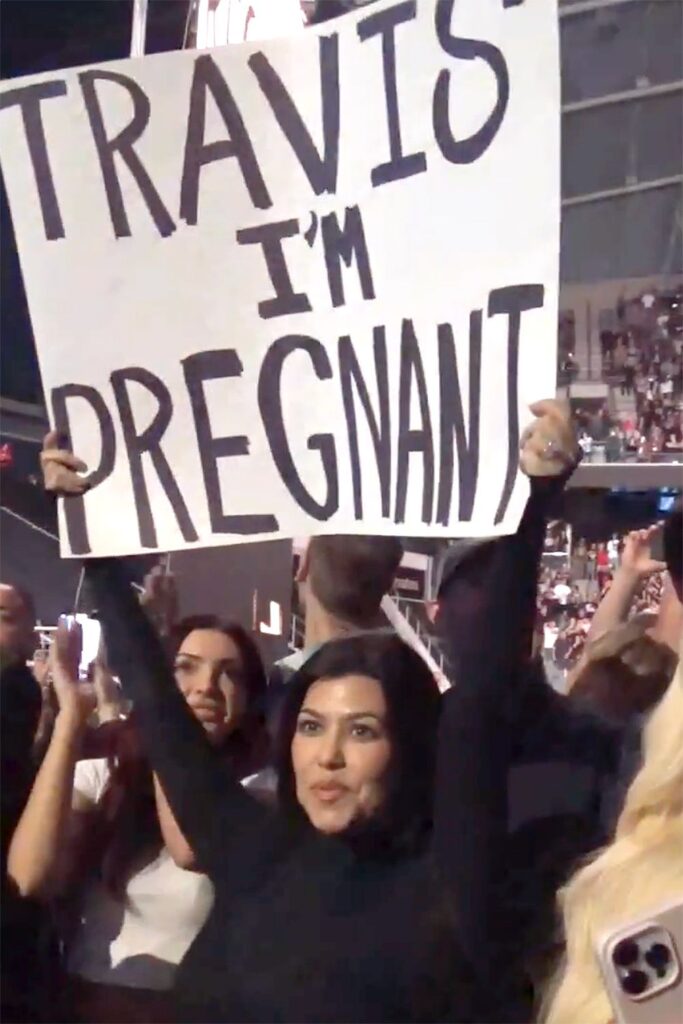 Kourtney Kardashian proudly held up a sign that read "Travis I'm pregnant"